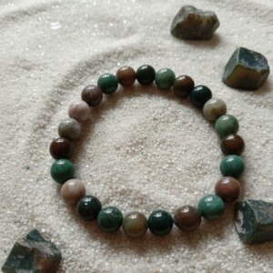 bracelet en pierre naturelle de 8 mm en agate indienne posé sur sable fin