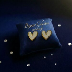 Boucles d'oreille cœur nacré sur son coussin bleu